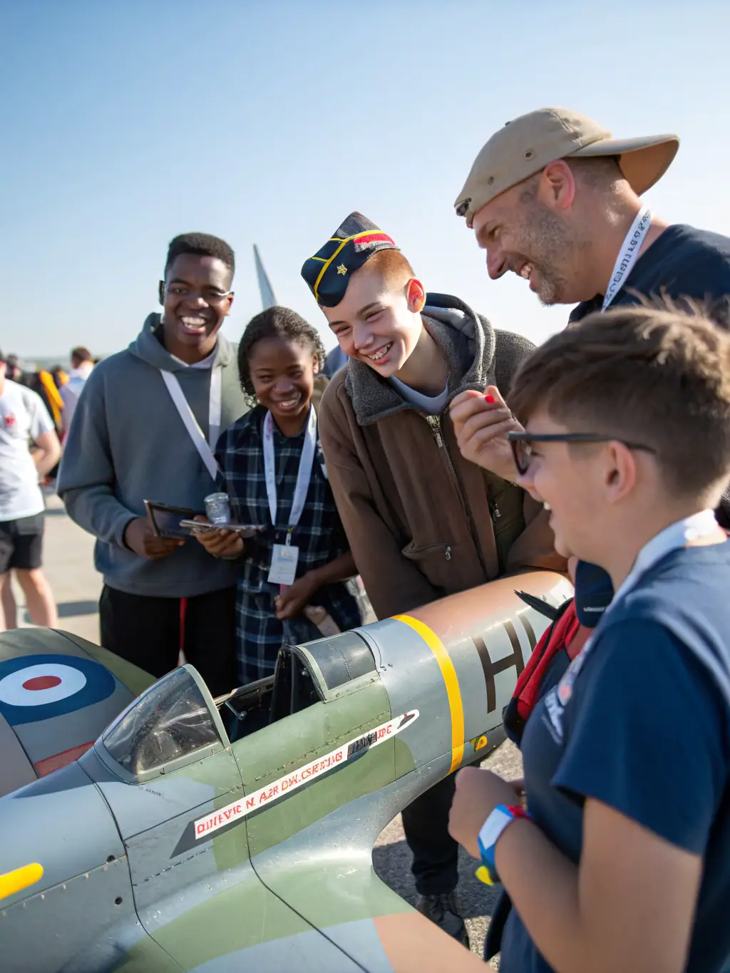A group of AERO CLUB DE SAINTES members gathered at the airfield, smiling and interacting, showcasing the strong sense of community and camaraderie.